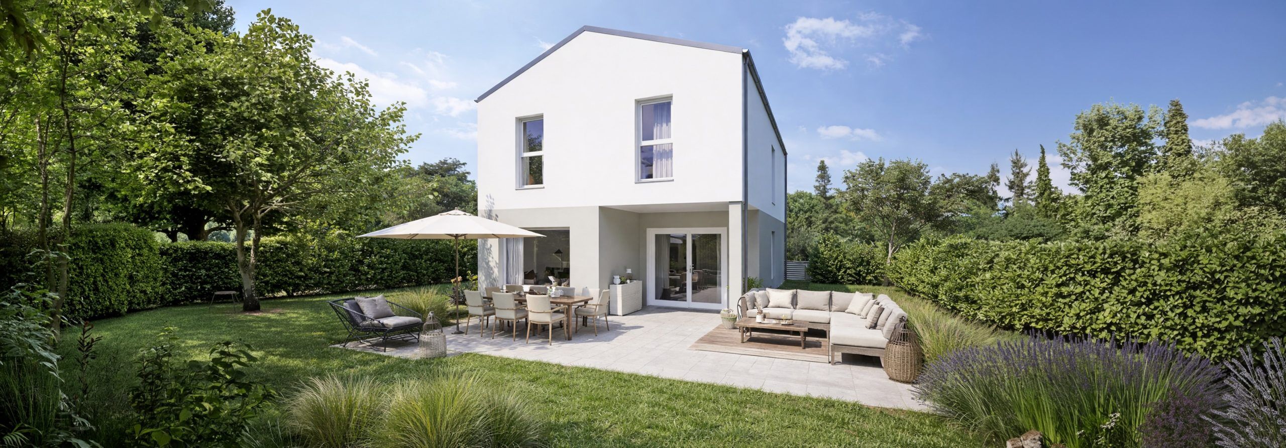 Modernes weißes zweistöckiges Haus mit großen Fenstern, umgeben von einem grünen Rasen und Bäumen. Der Hinterhof hat eine Terrasse mit Esstisch, Sonnenschirm und Sitzgelegenheiten unter blauem Himmel.